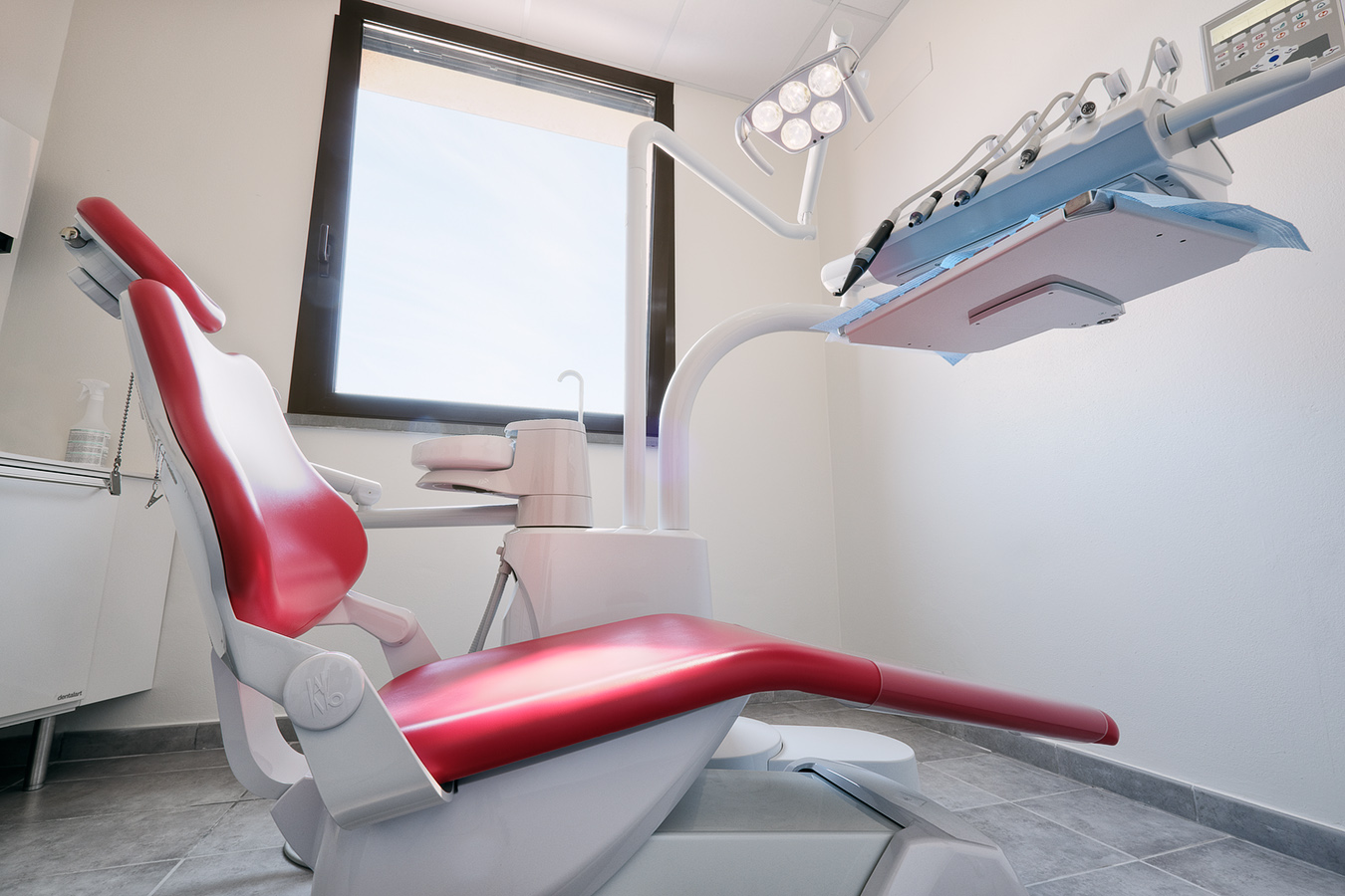 Dental cabinet: dentist's chair and tools. The room has a nice bright window